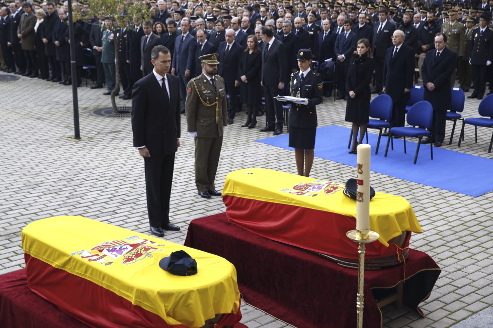 -FOTODELDIA- GRA223. MADRID, 15/12/2015.- El Rey Felipe VI tras imponer sobre uno de los féretros la Cruz de Oro al Mérito Policial a título póstumo, durante el funeral de Estado por los policías Jorge García Tudela e Isidro Gabino San Martín Hernández, fallecidos en el atentado talibán perpetrado en la embajada española en Kabul (Afganistán), que se celebra hoy en el complejo policial de Canillas en Madrid. EFE/J. J. Guillén ***POOL***