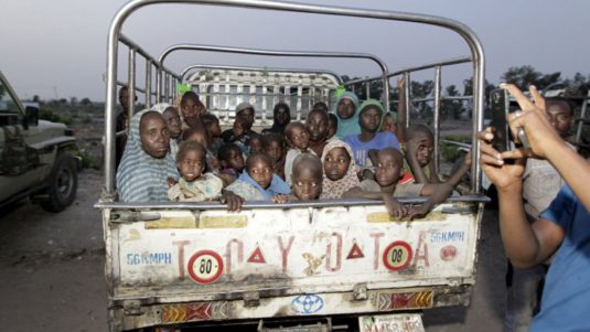 Niños y adultos católicos nigerianos masacrados sobreviven al ataque en Benue y son trasladados en una camioneta improvisada.