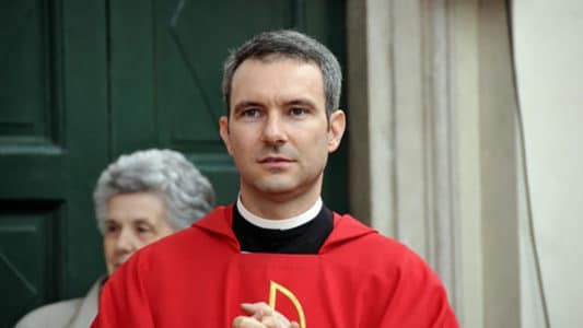 Carlo Capella vestido con sotana roja durante acto oficial, en el contexto de su reincorporación a la Secretaría de Estado.