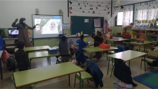 Niños en el aula interactúan con contenido proyectado, representando el uso de pantallas en la infancia digital