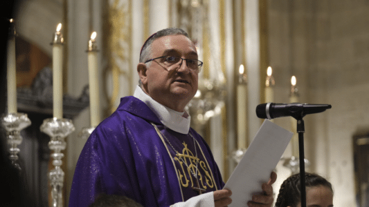 Obispo de Almería vestido con ornamentos litúrgicos morados leyendo un documento durante una ceremonia religiosa