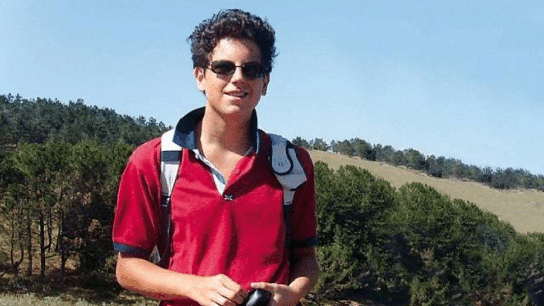 Carlo Acutis durante una caminata al aire libre con mochila y gafas de sol