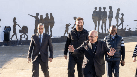 El sacerdote expulsado y condenado andando detrás a la derecha de la imagen del obispo Gómez Sierra