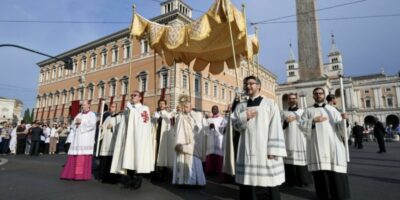 El papa León XIV porta la custodia bajo palio durante la procesión del Corpus Christi en Roma, rodeado de clérigos.