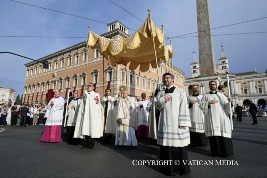 El papa León XIV porta la custodia bajo palio durante la procesión del Corpus Christi en Roma, rodeado de clérigos.
