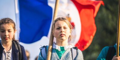 Joven peregrina con bandera de Francia durante la peregrinación de Pentecostés en Chartres.