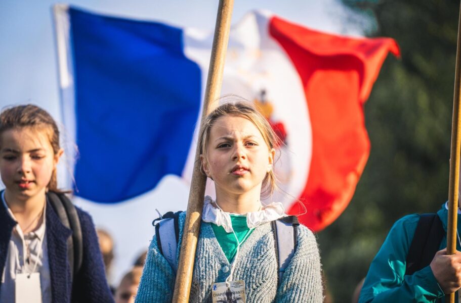 Joven peregrina con bandera de Francia durante la peregrinación de Pentecostés en Chartres.