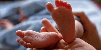 Pies de un recién nacido sostenidos por una mano adulta, símbolo de la vida frente a las consecuencias del aborto en Irlanda.