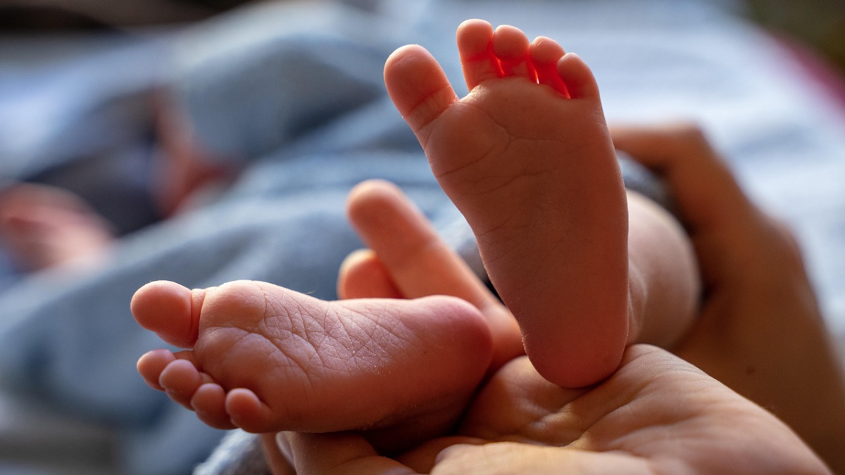 Pies de un recién nacido sostenidos por una mano adulta, símbolo de la vida frente a las consecuencias del aborto en Irlanda.