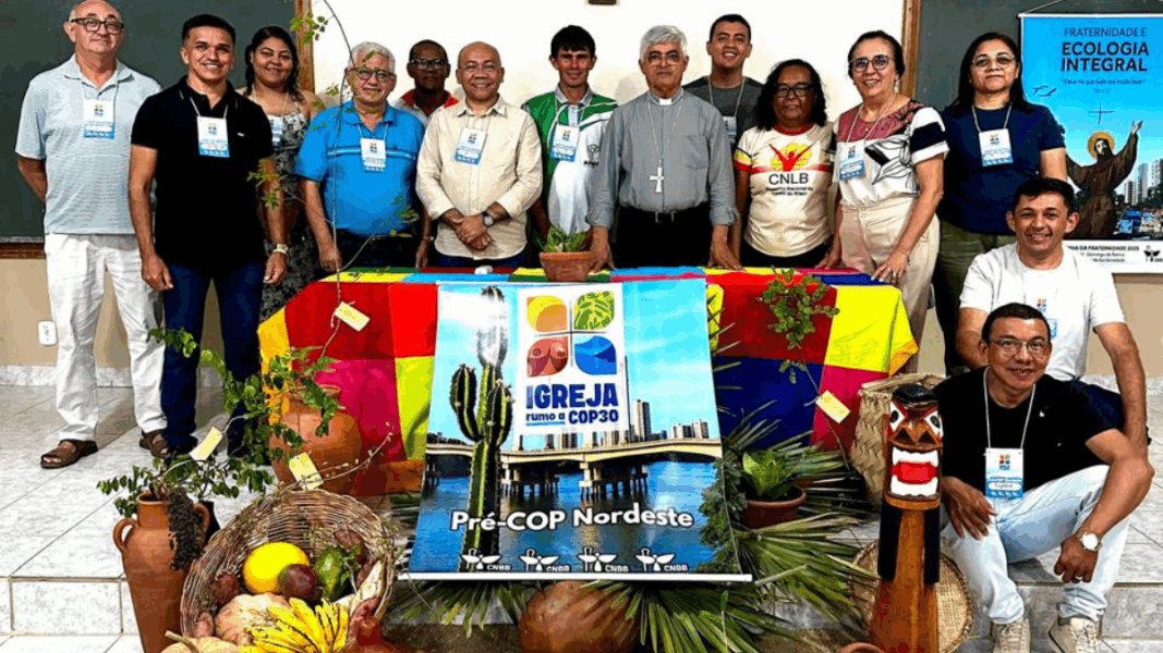 Participantes de la Pre-COP30 en Brasil posan junto a obispos y líderes comunitarios con símbolos ecológicos y religiosos.