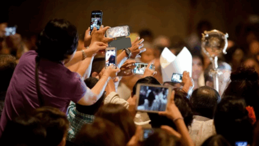 Feligreses tomando fotos durante un evento religioso, capturando momentos con sus teléfonos móviles, similar al Jubileo para influencers católicos.