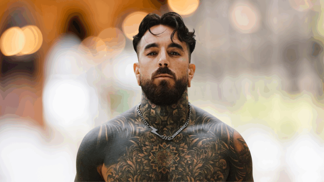 René ZZ tatuado mira al frente, protagonista del testimonio “Soñé que Dios me amaba”