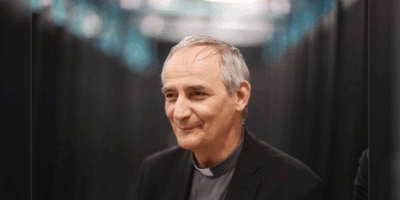 Cardenal Matteo Zuppi sonriendo, representando la importancia de abordar el problema de la paz.