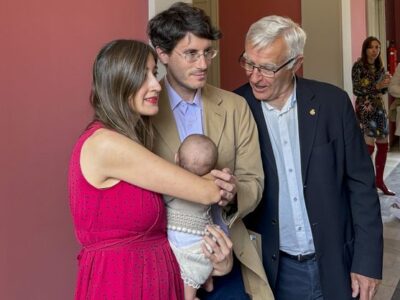 Padres con su hijo en brazos durante un bautizo civil, representación de los Hijos de Sánchez